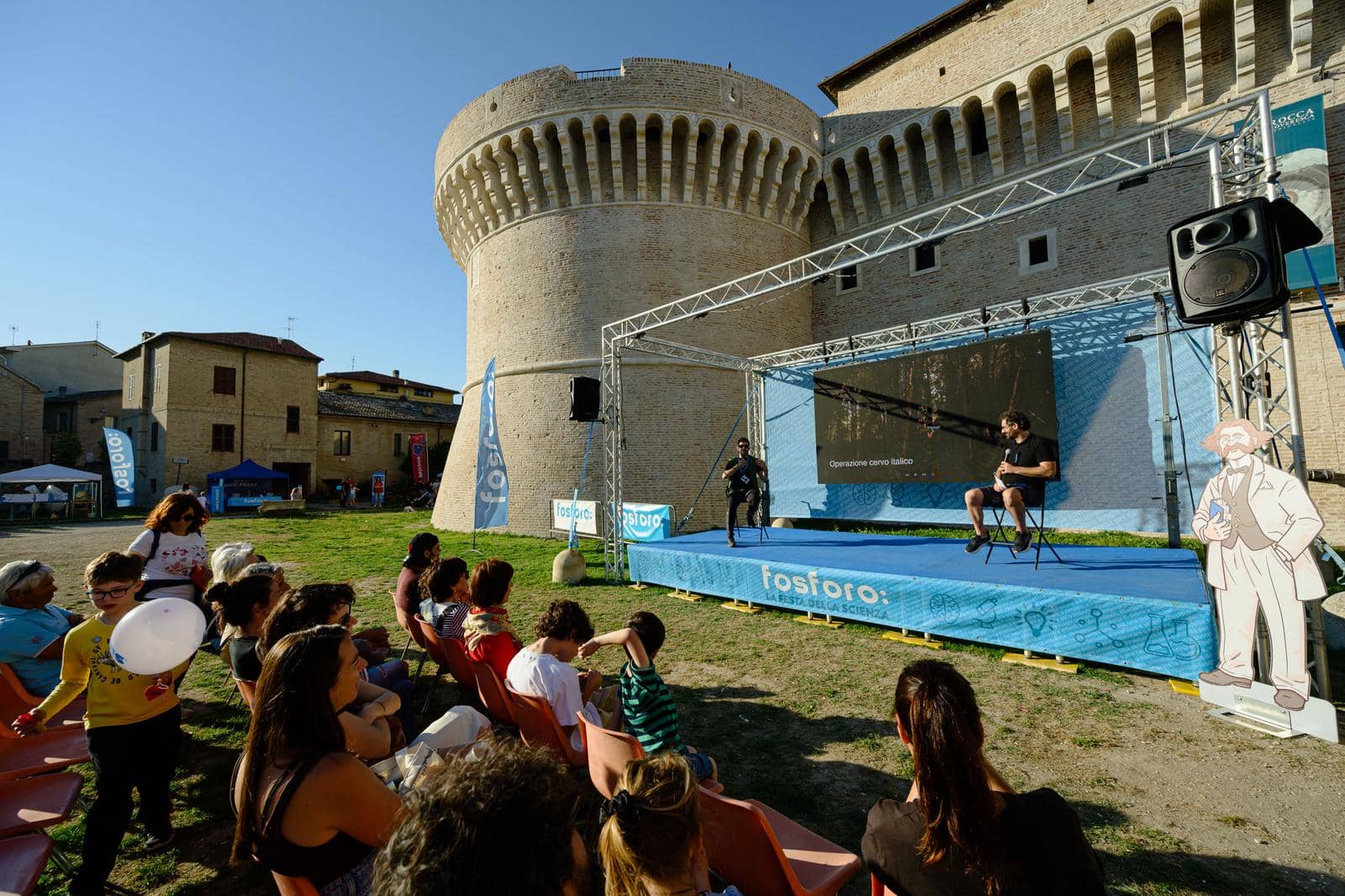 Il pubblico seduto davanti al palco ai piedi della Rocca Roveresca